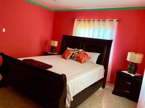 a bedroom with red walls and a bed with pillows at Moonlit Meadow B&B in Duncans