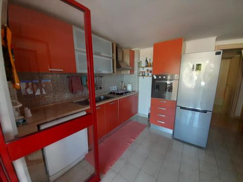 eine Küche mit roten Schränken und einem weißen Kühlschrank in der Unterkunft La casa di Arianna in Peschici