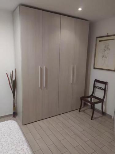 a bedroom with a closet with a chair and a cabinet at Garbatella seminterrato in Rome