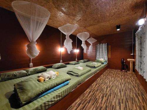 a bedroom with a large bed with two stuffed animals on it at บ้านมานอนดอย - Manondoi โฮมสเตย์เชียงดาว in Ban Pang Klang