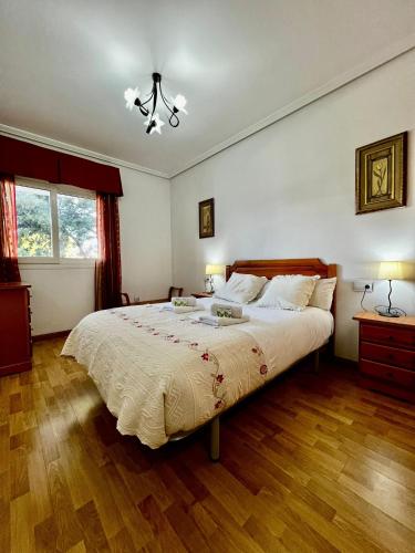 a bedroom with a large bed with wooden floors at 2 Bedroom Apartment in Puerto Marina in Benalmadena Costa