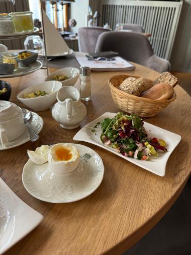 a wooden table with a breakfast of eggs and bread at Das Hotel Krone in Königswinter