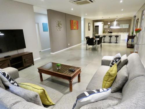 a living room with a couch and a coffee table at The Executive - Exclusive Self-Catering Apartments - Ezulwini in Ezulwini