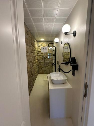 a bathroom with a sink and a stone wall at Paleos İmroz in Gökçeada