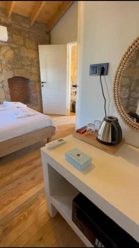 a bedroom with a bed and a table with a mirror at Paleos İmroz in Gökçeada