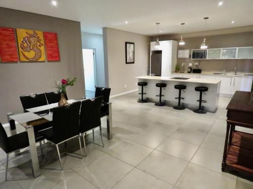 a kitchen and living room with a table and chairs at The Executive - Exclusive Self-Catering Apartments - Ezulwini in Ezulwini