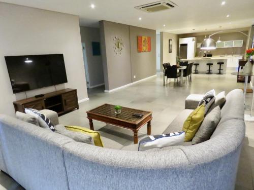 a living room with a couch and a table at The Executive - Exclusive Self-Catering Apartments - Ezulwini in Ezulwini