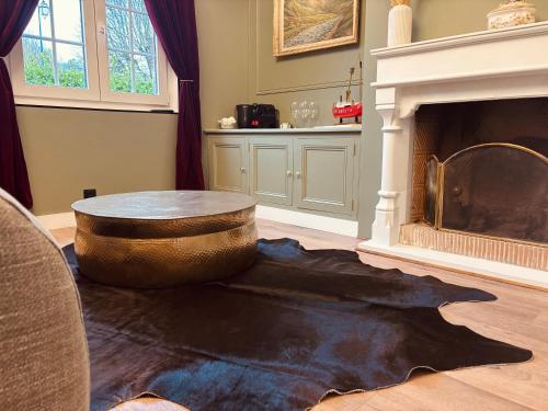 Una sala de estar con una mesa y una chimenea. en La Suite, en Étretat