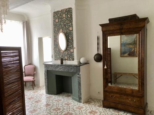 a living room with a fireplace and a mirror at Le Couvent des Ecrevisses in Barjols