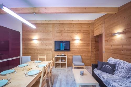 une salle à manger avec une table et un canapé dans l'établissement L'Ecrin du Val d'Arly - Vue montagne parking privé, à Flumet