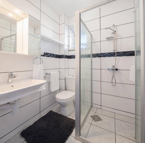 a bathroom with a toilet and a sink and a shower at La Perla Apartments 2 in Sutivan
