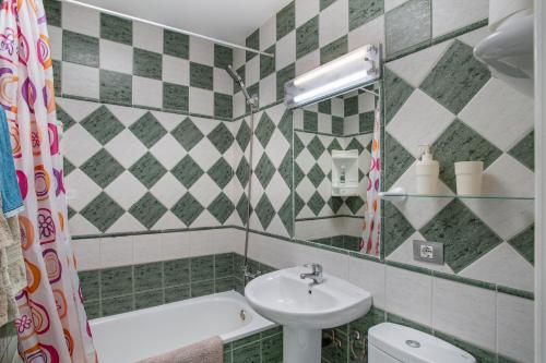 a bathroom with a sink and a tub and a toilet at Dunaflor Gemelo 3 in San Bartolomé de Tirajana