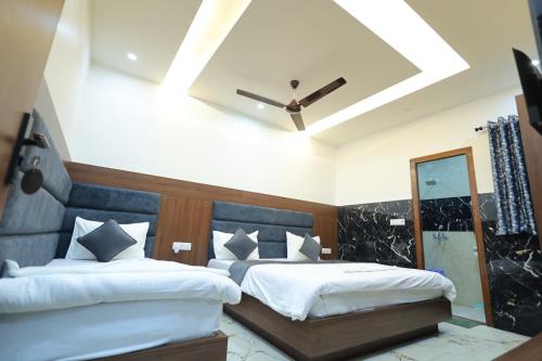 a bedroom with two beds and a ceiling at Shri Bankey Bihari Home Stay in Vrindāvan