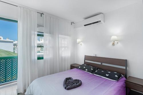 a bedroom with a bed with a heart pillow on it at Dunaflor Gemelo 3 in San Bartolomé de Tirajana