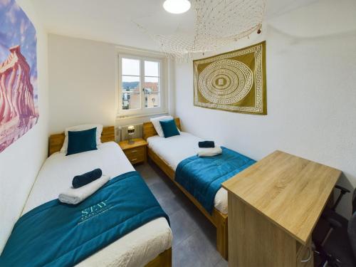 una camera con due letti e un tavolo in legno di The5Continents III - Youth Hostel by Stay Swiss a Porrentruy