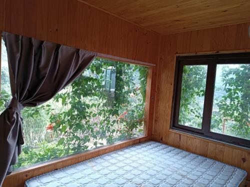 a room with a window with a bed in it at Chalet Bungalow Kala by Tâm Miên Man Homestay in Di Linh