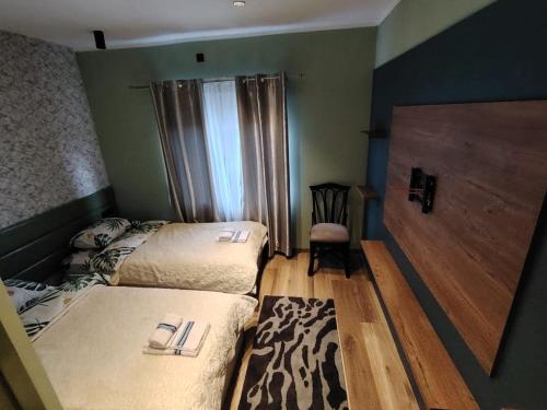 a small bedroom with two beds and a chair at Gazdinstvo Tadić in Nikšić