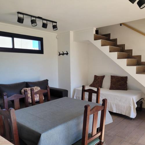 a room with a table and a bed and a staircase at Duplex a estrenar!! Zona Parque in Necochea