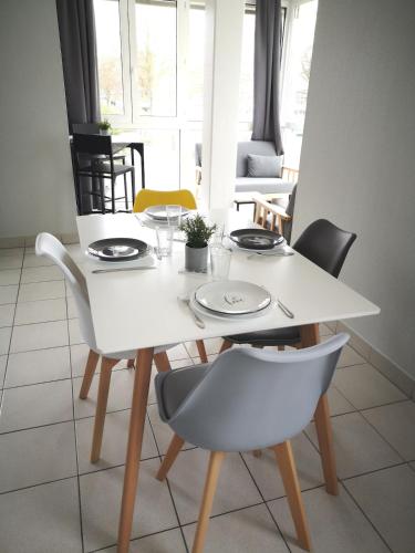 - une table à manger blanche avec des chaises, une table blanche et des chaises dans l'établissement Très bel appartement avec vue d'exception & parking, à La Rochelle