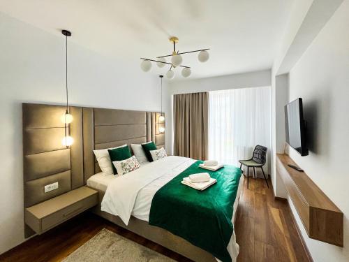 a bedroom with a large bed with a green blanket at Alegria Avantgarden Brasov in Braşov
