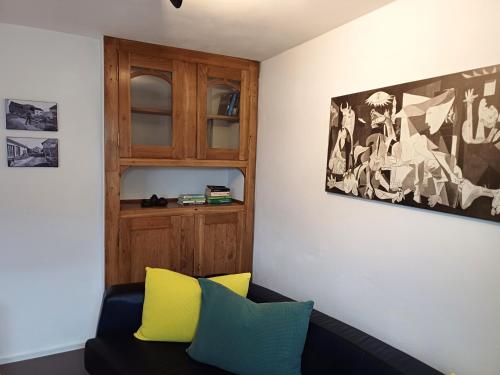 a living room with a black couch and yellow pillows at Denkmalgeschütztes Ferienhaus in der Südeifel - Ferienhaus HAZEN in Bettingen