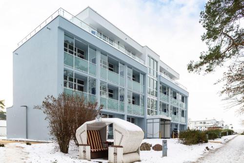 a large building with two chairs in the snow at Hotel Seebrücke in Lubmin
