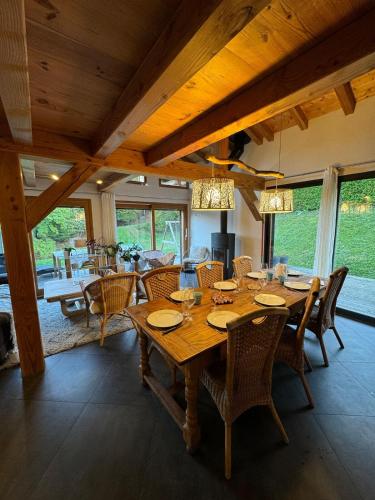 une salle à manger avec une grande table et des chaises en bois dans l'établissement Wood chalet -Poêle à bois - proche ski et télécabine, à Morillon