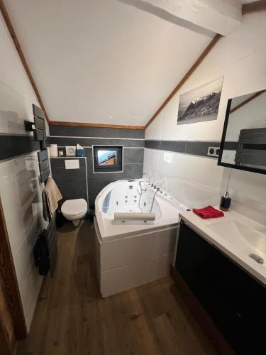une salle de bain avec une baignoire, des toilettes et un lavabo dans l'établissement Wood chalet -Poêle à bois - proche ski et télécabine, à Morillon