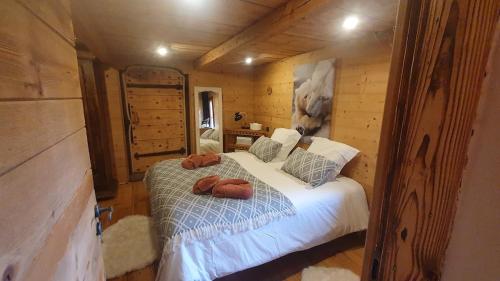 ein Schlafzimmer mit einem Bett in einer Blockhütte in der Unterkunft Wood chalet -Poêle à bois - proche ski et télécabine in Morillon