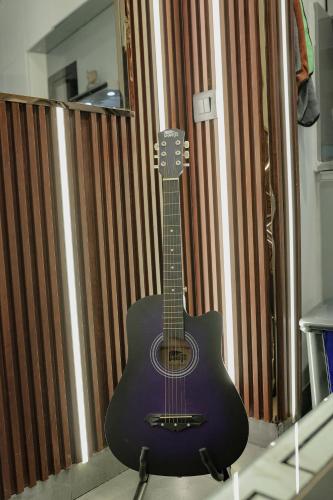 a guitar sitting on top of a shelf at Lux Paradise By Aurum in Noida