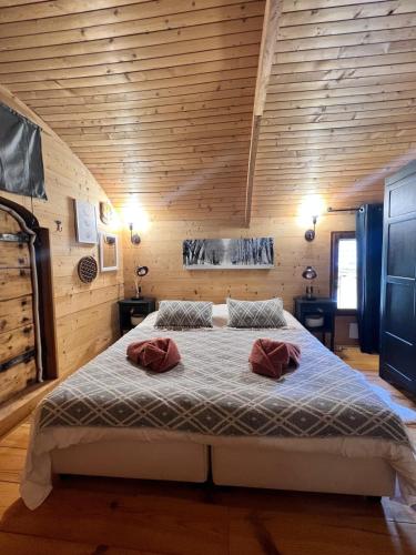 une chambre avec un lit avec deux oreillers dessus dans l'établissement Wood chalet -Poêle à bois - proche ski et télécabine, à Morillon