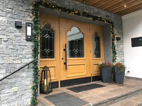 una casa con una porta gialla con luci di Natale di Pension Kristall a Flirsch