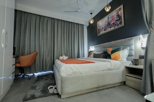 a bedroom with a large bed and a desk at Lux Paradise By Aurum in Noida