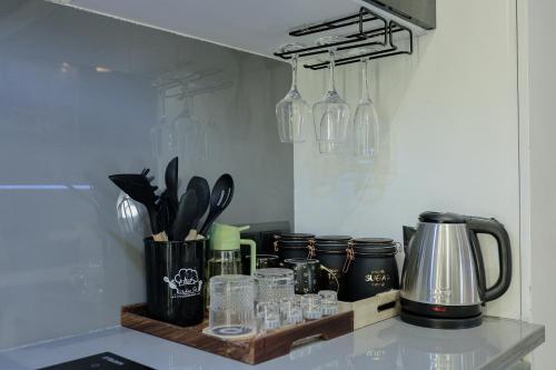 a kitchen with a counter with glasses and bottles at Lux Paradise By Aurum in Noida