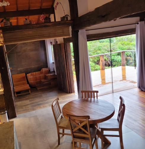 a dining room with a wooden table and chairs at Vila Santiago - Chalé Quaresmeira in Santana do Riacho