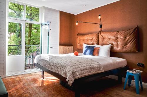a bedroom with a large bed and a large window at Max Brown Hotel Museum Square, part of Sircle Collection in Amsterdam
