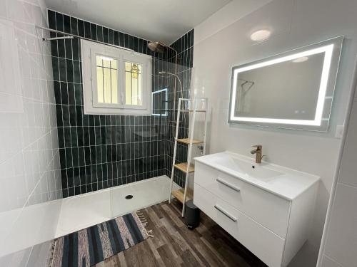 a bathroom with a white sink and a mirror at Les Saules in Saint-Gilles-Croix-de-Vie