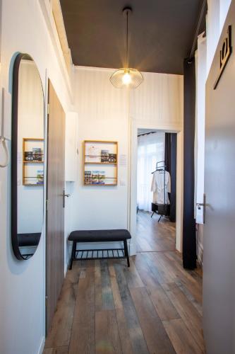 - un couloir avec un banc et un miroir dans la chambre dans l'établissement L'Hyper Centre - Netflix & Wifi - Literie Haut de Gamme - check-in 24H24 - GoodMarning, à Châlons-en-Champagne