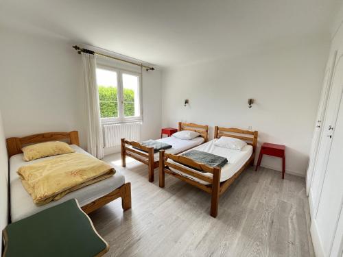 a bedroom with two beds and a window at Les Saules in Saint-Gilles-Croix-de-Vie