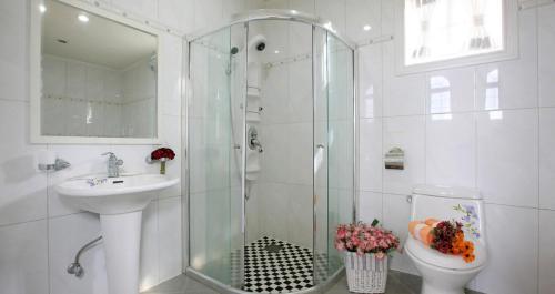 a bathroom with a shower and a toilet and a sink at Daegwanryeong Sketch Pension in Pyeongchang