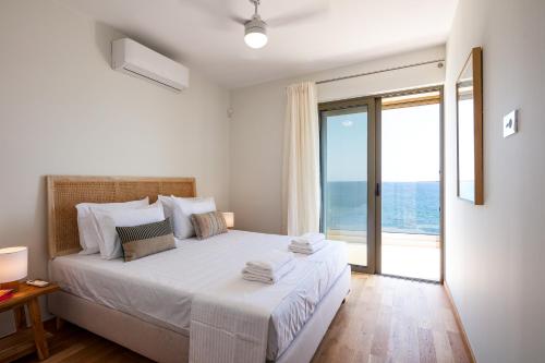 a bedroom with a large bed with a large window at Kalyves Coastal Retreat in Chania Town