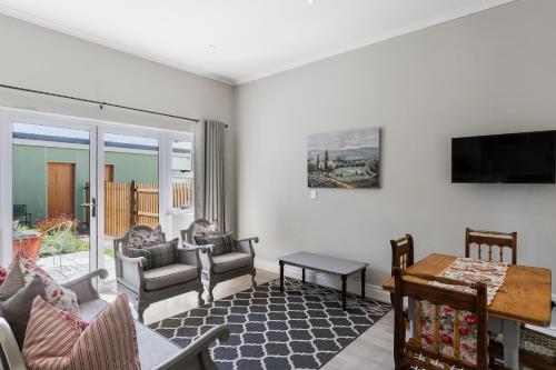 a living room with a tv and a couch and a table at Twelve on Arum in Somerset West