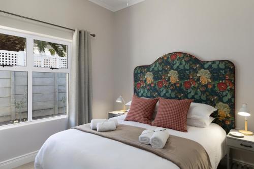 a bedroom with a large bed with a floral headboard at Twelve on Arum in Somerset West