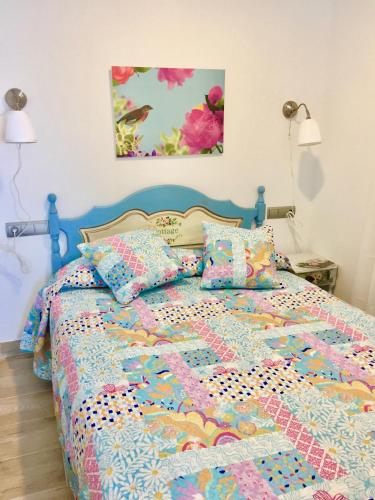 a bed with a colorful quilt and pillows on it at Apartamento Torre San Francisco in Benalmádena