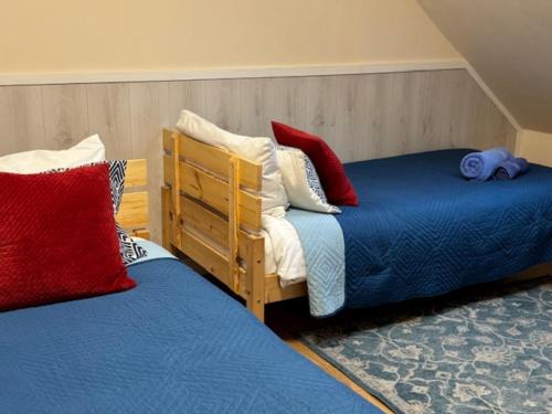 a bedroom with two beds with red and white pillows at Agroturystyka Staroscin in Rzepin