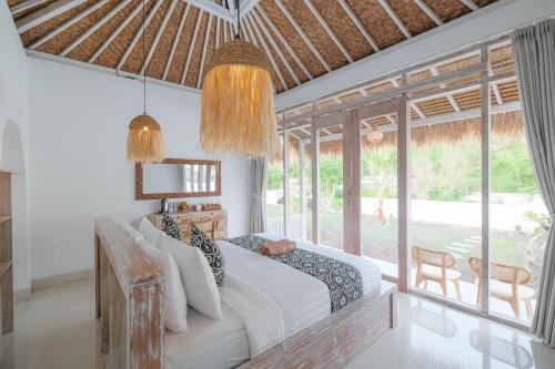a bedroom with a bed and a large window at Bunbulan sunshine in Kubupenlokan