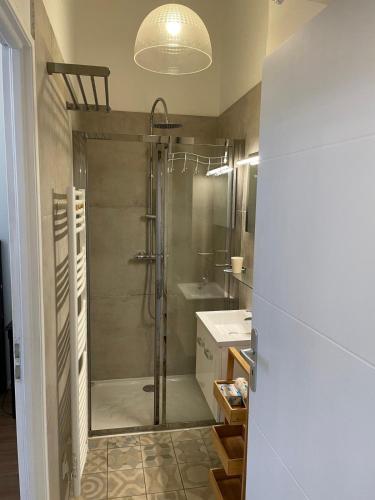 une salle de bain avec douche et lavabo dans l'établissement Emplacement rare élégant appartement avec balcon sur le Canal Royal, à Sète