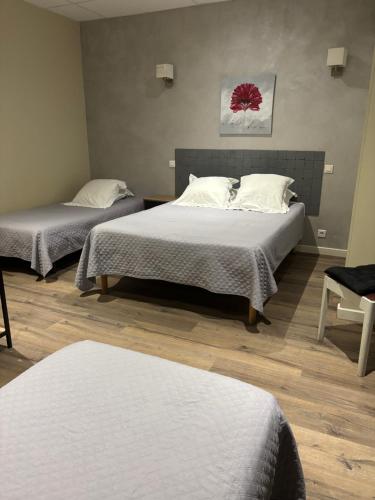 a room with two beds and a chair in it at Hôtel Restaurant Les Chasseurs in Marine de Pietracorbara