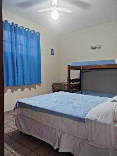 a bedroom with a bed and a blue curtain at Casa Monjardim in Vitória