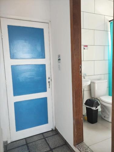 a door to a bathroom with a toilet and a sink at Casa Monjardim in Vitória